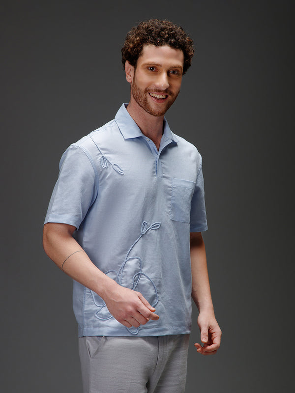 Man wearing a light blue organic cotton shirt with a subtle pattern 