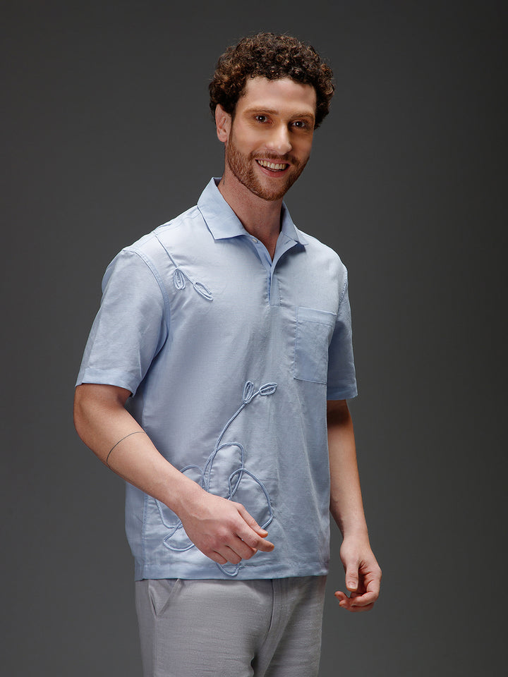 Man wearing a light blue organic cotton shirt with a subtle pattern 