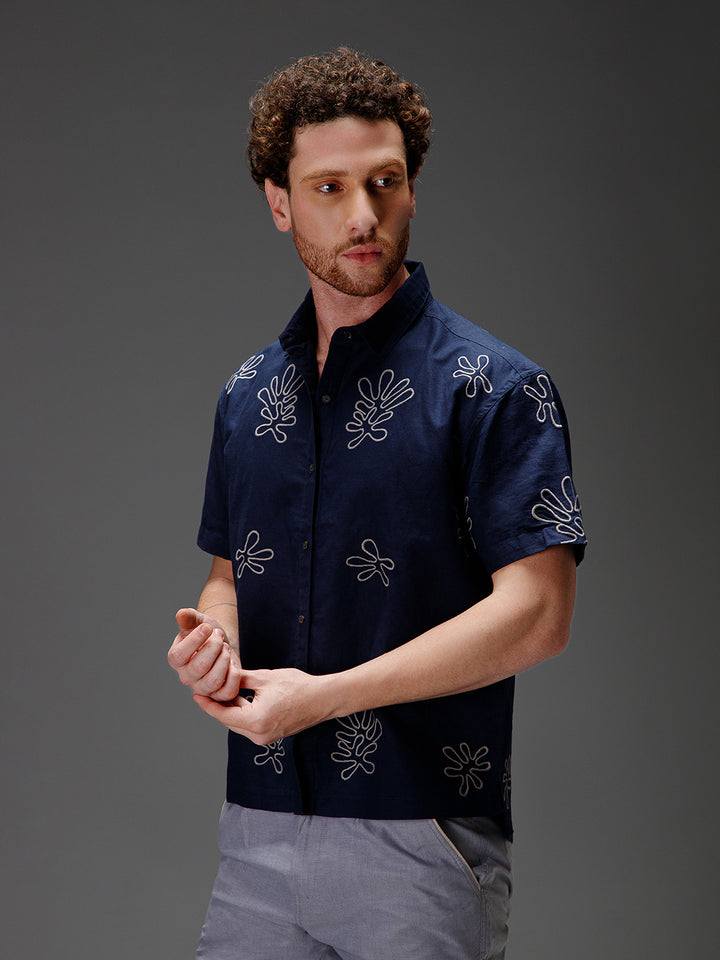 Man wearing a dark blue cotton linen shirt with white patterns 
